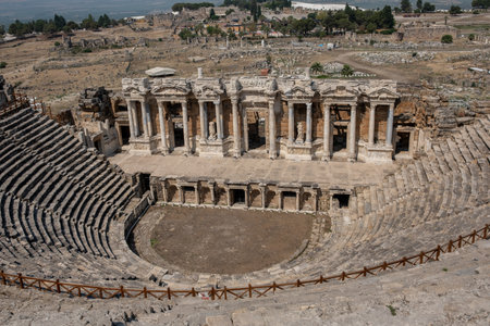 Explore the stunning ancient theater at Pamukkale, showcasing intricate architecture and rich history, nestled among the ruins of an ancient settlement.の写真素材