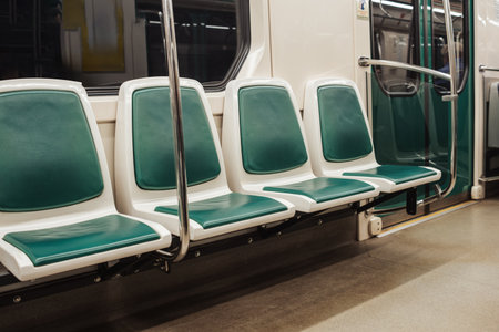 Rows of clean subway train seats in green and white are ready for commuters in a modern urban transit system during a peaceful morning time.の写真素材