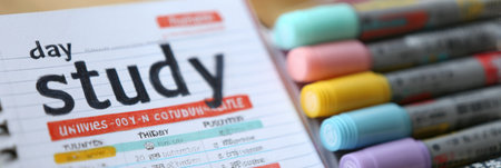 A well-organized planner opened to a study schedule features colorful highlighters and notes indicating subjects and assignments in a bright workspace.の素材