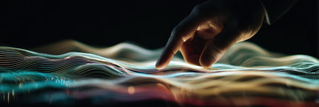 A hand interacts with flowing, vibrant waves of light in a dimly lit environment, showing the connection between human touch and digital art.の素材