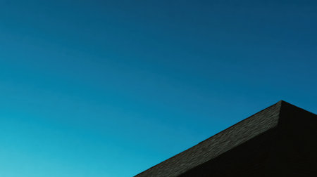 A striking modern structure emerges against a backdrop of a deep blue sky at dusk, highlighting geometric lines and innovative architecture in an urban setting.の素材