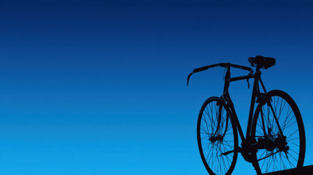 A striking silhouette of a bicycle is highlighted against a deep blue sky at dusk, emphasizing the quiet beauty of cycling during twilight hours.の素材