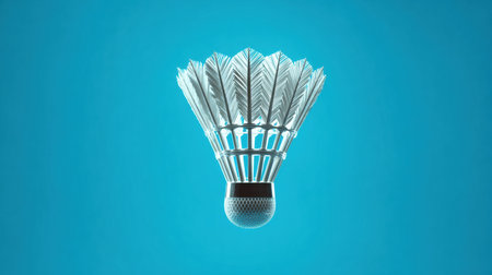 A shuttlecock floats against a smooth blue backdrop, showing its intricate feather design and structure, ideal for sports enthusiasts and badminton lovers.の素材