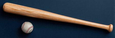 A wooden baseball bat lies beside a classic baseball on a dark surface, hinting at a game played during a sunny afternoon in the park.の素材