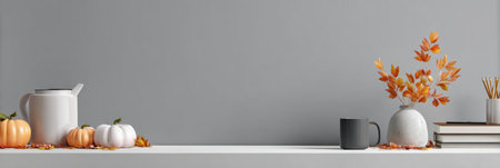 A cozy autumn display features miniature pumpkins, a modern vase with orange flowers, and simple tableware on a clean white shelf against a gray backdrop.の素材