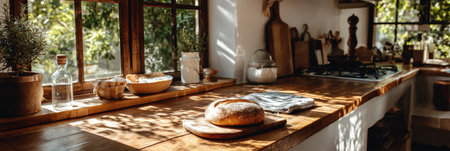 A rustic kitchen with a wooden countertop, fresh bread, bowls of ingredients, and sunlight creates a cozy atmosphere.の素材