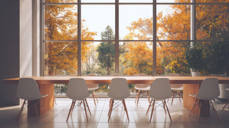 Spacious dining space features a long wooden table with stylish chairs and large windows highlighting colorful autumn trees outside.の素材
