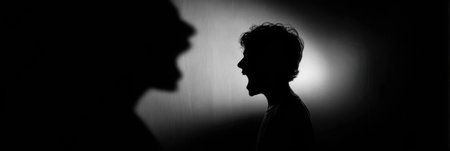 A calm person in the foreground contrasts with their shadowy figure shouting, reflecting inner turmoil versus outer demeanor.の素材