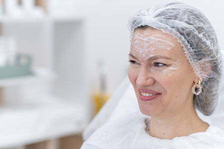 Patient engages happily in consultation for botulinum therapy at a contemporary clinic, showing her anticipation and confidence in the treatment process.の写真素材
