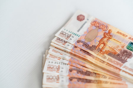 Stack of 5000 ruble banknotes displayed on a clean white surface, showing clear details and colors...