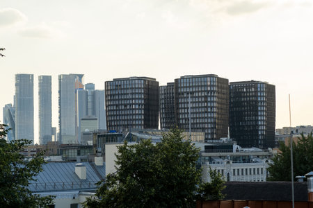Tall buildings form a modern urban backdrop, while unique shapes in the foreground create a dynamic skyline.の写真素材