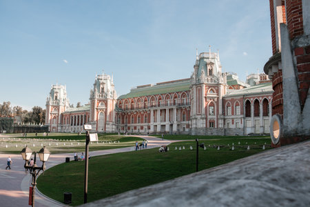 Visitors explore the grounds of Tsaritsyno, enjoying the impressive palatial architecture and lush green landscapes under a bright blue skyの写真素材