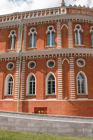 Discover the stunning exterior of Tsaritsyno, showcasing red brick walls, arched windows, and decorative patterns under a bright sky in Moscow.の写真素材