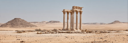 Ancient columns rise prominently amidst a vast desert, showcasing the remnants of a past civilization in a serene, sunlit scene that captures history.の素材