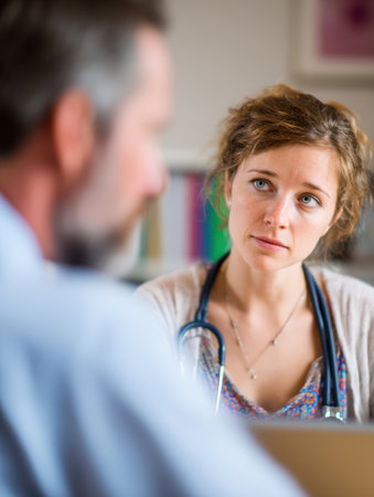 Healthcare worker attentively listens to a patient in a well-lit medical office during a consultation, focused on understanding his needs.の素材