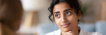 A woman engages in a thoughtful conversation, showing interest and empathy in a comfortable room filled with natural light.の素材