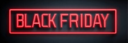 Neon lights illuminate the Black Friday text in a dark background, creating an eye-catching display for upcoming sales and discounts for shoppers.の素材