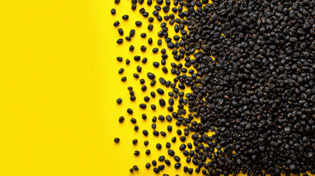 Dark seeds are arranged on a vivid yellow background, showing an eye-catching contrast that emphasizes the texture and shape of the seeds.の素材