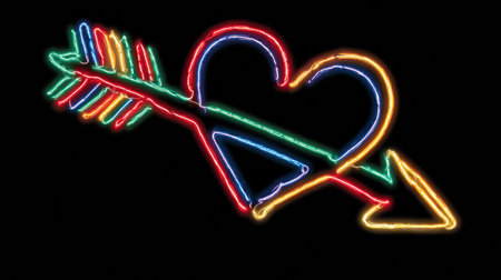 A vibrant neon heart is pierced by a colorful arrow, creating a striking visual in bright hues against a dark backdrop.の素材