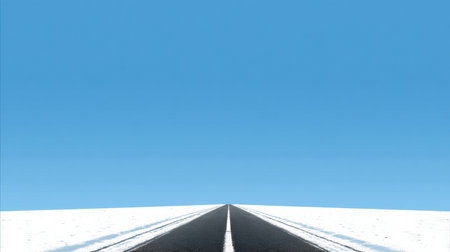 A long, straight road leads through vast white snowfields, covered under a bright blue sky, showing the serene beauty of winter scenery.の素材