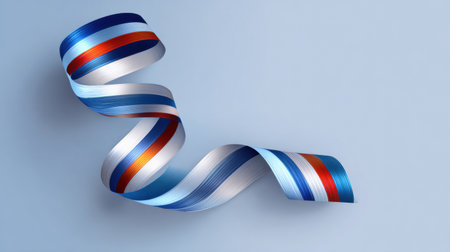Twisted ribbon with red, white, and blue stripes rests on a soft blue surface, contributing to a vibrant and artistic composition for design ideas.の素材