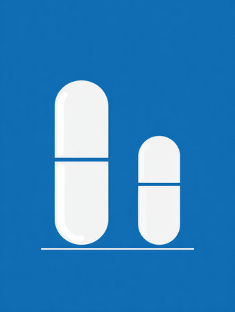 Two white capsules of varying sizes are displayed against a bright blue background, highlighting their differing dimensions for pharmaceutical representation.の素材