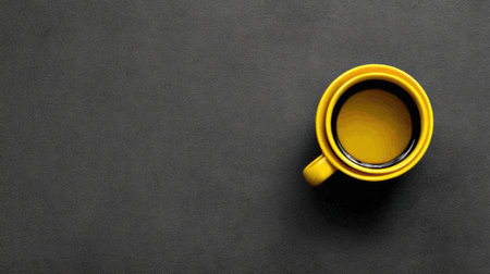 A yellow cup on a dark surface holds rich coffee, creating a striking contrast that highlights the cups warmth and the brews richness.の素材
