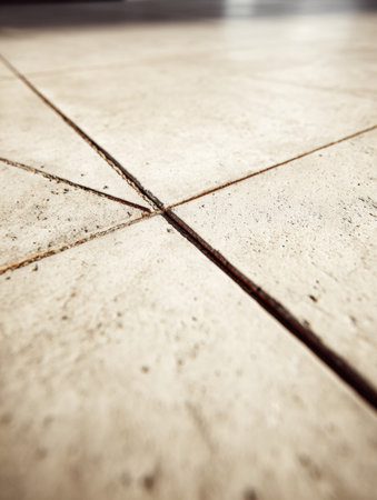 Close-up of a flooring surface highlighting grout lines and texture in soft natural light, showcasing design.の素材