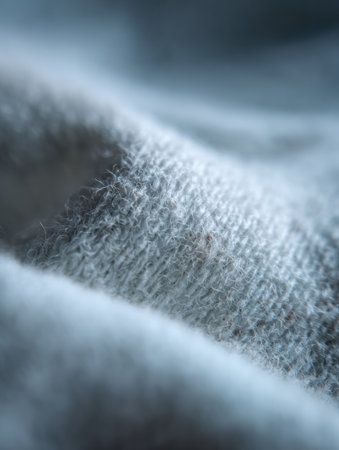 Close-up view of soft gray fabric highlights intricate textures and fibers, revealing the quality of the textile.の素材