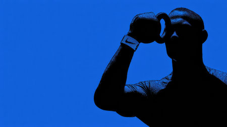 A person trains with a kettlebell, silhouetted against a bright blue backdrop, showing focus and determination.の素材