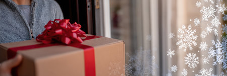Individual is seen delivering a brown present wrapped with a red ribbon and bow. Snowflakes decorate the background.の素材