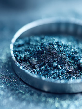 Fine blue pigment is displayed in a circular dish, highlighting its rich texture and color against a blurred backgroundの素材