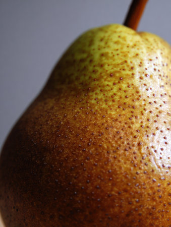 A close-up of a fresh pear showing its smooth skin, vibrant colors, and natural features for food lovers.の素材