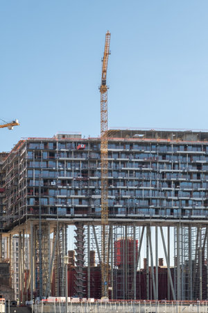 Construction Project in Urban Area Featuring Crane and Elevated Building Under Development in Bright Daylightの写真素材