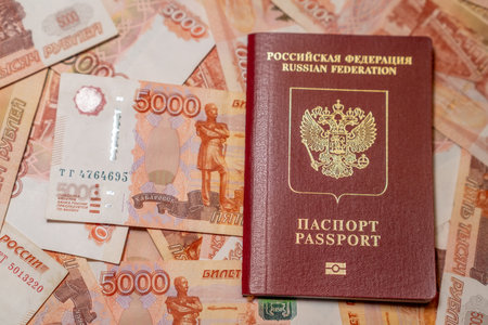 A Russian passport on a stack of 5000 ruble notes reflects wealth and national identity.の写真素材