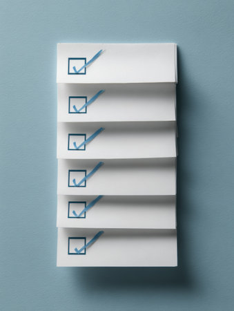 Stack of white checklists with blue check marks on a smooth blue surface, illustrating organized task completion and planning.の素材