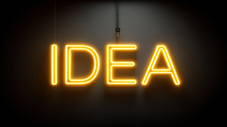A vibrant yellow neon sign that reads idea is illuminated against a dark wall, creating an inspiring atmosphere for creativity.の素材