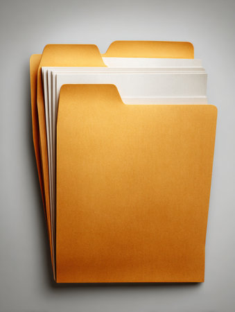 Several yellow file folders arranged in an orderly manner against a gray backdrop, highlighting a sense of organization and structure.の素材