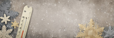 Decorative snowflakes surround a vintage thermometer as gentle snow fall creates a cozy winter atmosphere.の素材