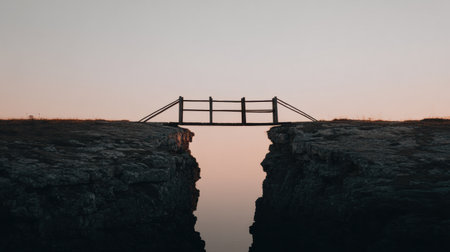 A half-built wooden bridge stretches over a deep chasm, highlighting challenges of unfinished work during twilight with soft colors.の素材