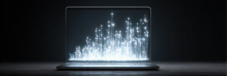 Laptop shows glowing data charts, representing business trends and analytics, illuminating a dark workspace in the evening.の素材
