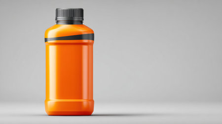 Bright orange engine oil bottle stands alone against a light gray background, highlighting the products clean and modern design appeal.の素材