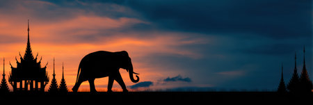 Elephant walks gracefully in front of a traditional Thai temple as the sun rises, filling the sky with warm cinematic colors.の素材