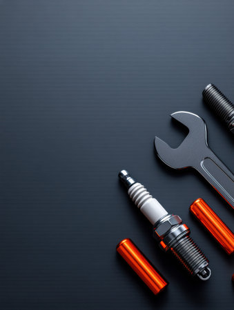 Spark plug and wrench laid out in a minimal design on a dark gradient background, highlighting tools for vehicle maintenance and repair.の素材