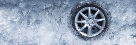 The clear ice surface displays a car wheel outline set against a frosty backdrop, with space available for text on the left side.の素材