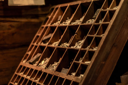Vintage Wooden Letterpress Tray Filled With Assorted Type Pieces in an Old Workshop Setting During Daytimeの写真素材
