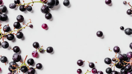 Grapes are gently scattered across a white background, showcasing a serene and minimalistic aesthetic in a bright settingの素材