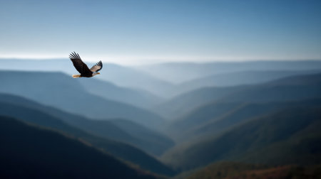 A bald eagle flies high above mountain ranges under a clear sky, symbolizing freedom and traditional values in native American culture.の素材