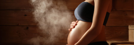 A pregnant woman enjoys the warmth of a sauna, experiencing heavy sweating while focusing on relaxation and detoxification.の素材