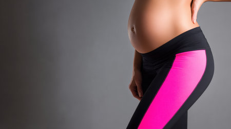 The person stands with a side profile showing a noticeable belly bulge while wearing vibrant leggings, emphasizing fitness and style.の素材